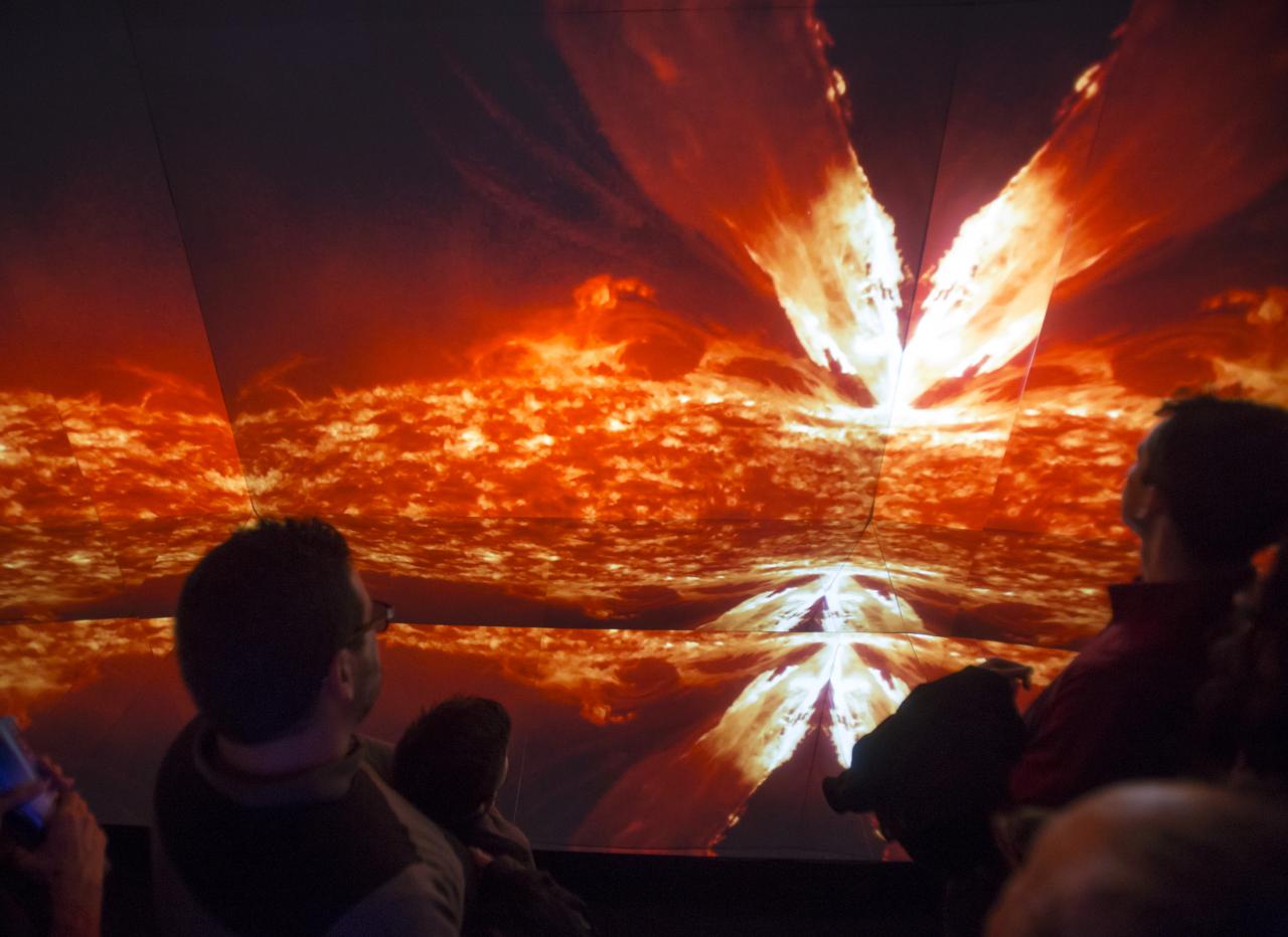 Visitantes de la exposición "Luces del Universo" ante el módulo "Caleidoscopio GTC", donde se proyectan imágenes astronómicas con efecto envolvente
