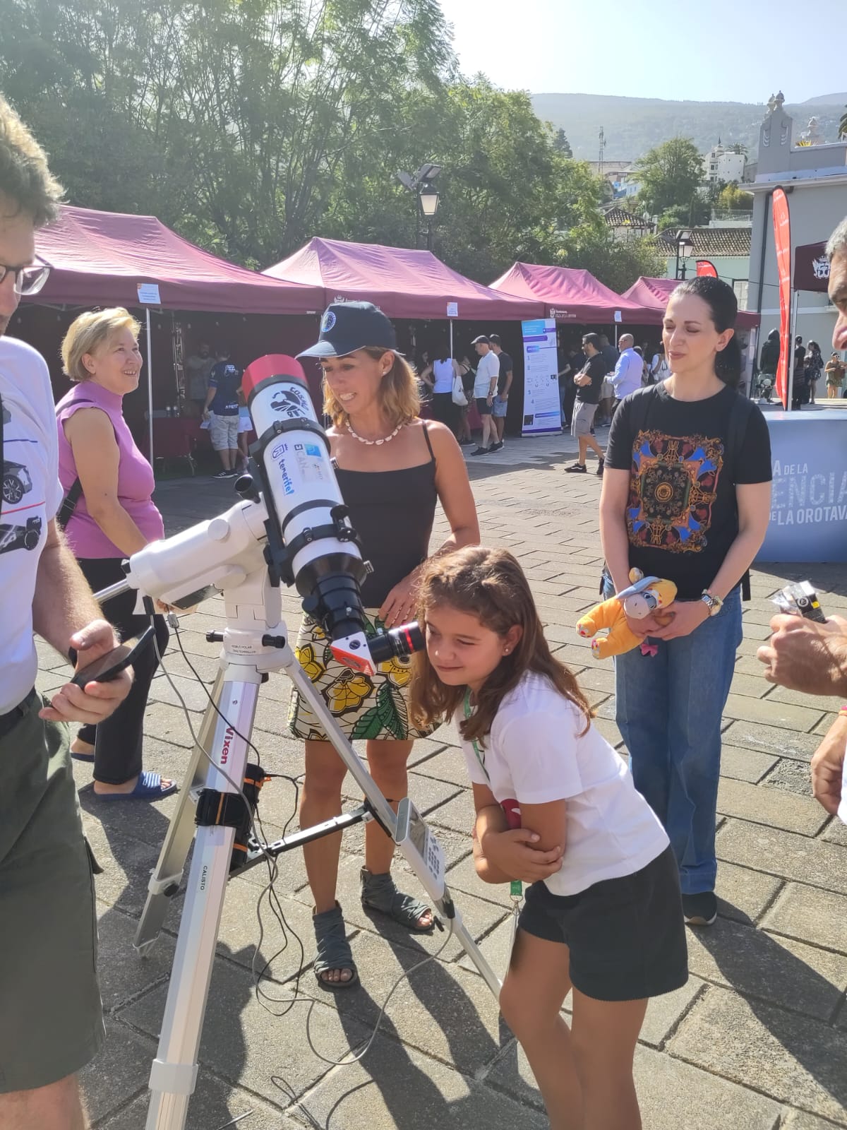 Una niña mira por el telescopio solar del Instituto de Astrofísica de Canarias en la Feria de la Ciencia de la Orotava