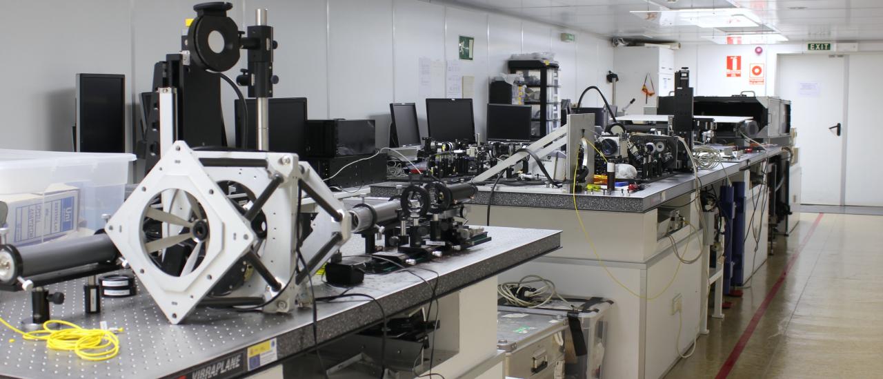 General view of one of the rooms (A) of the optical laboratory. Elongated laboratory with metal tables with holes and various optical and mechanical elements on top of them