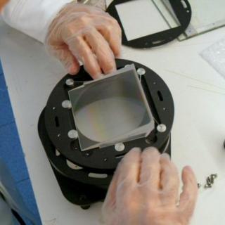 Vista de un ingeniero montando un grisma en el laboratorio Vista de un ingeniero montando un grisma en el laboratorio. Ingeniero ajustando un prima sobre una montura metálica